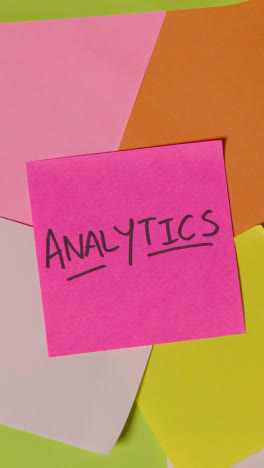 Vertical-Video-Business-Concept-Of-Revolving-Sticky-Notes-With-Analytics-Written-On-Top-Note